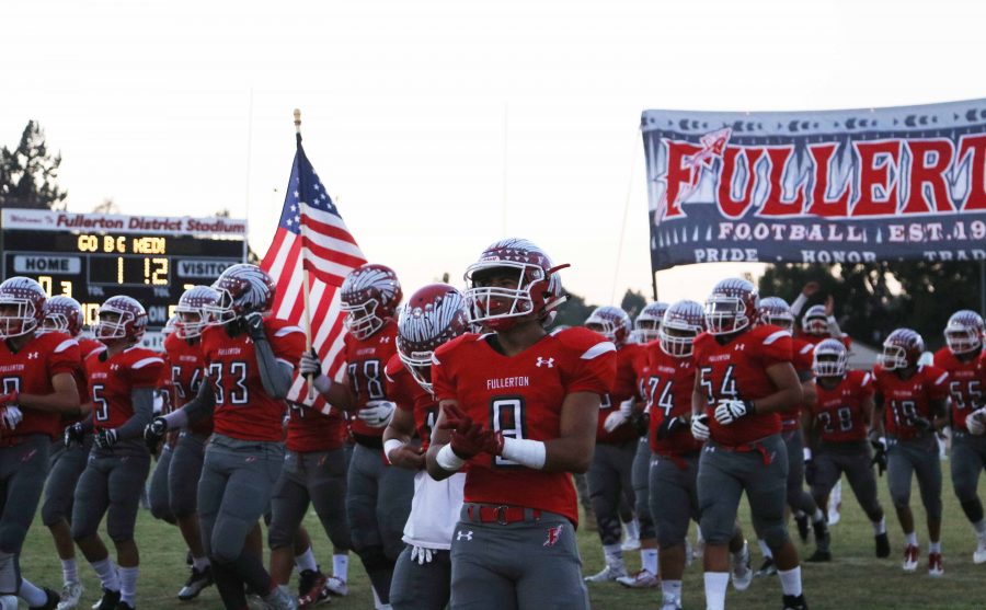 The Indians running under the banner before facing El Modena on Sept. 16. Photo by Emily Caluya.