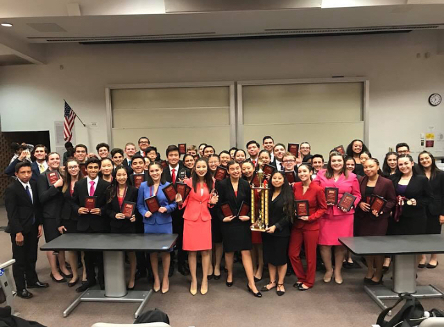 The+Speech+and+Debate+team+poses+with+their+first+place+trophy.+Photo+courtesy+of+Priscilla+Merit.