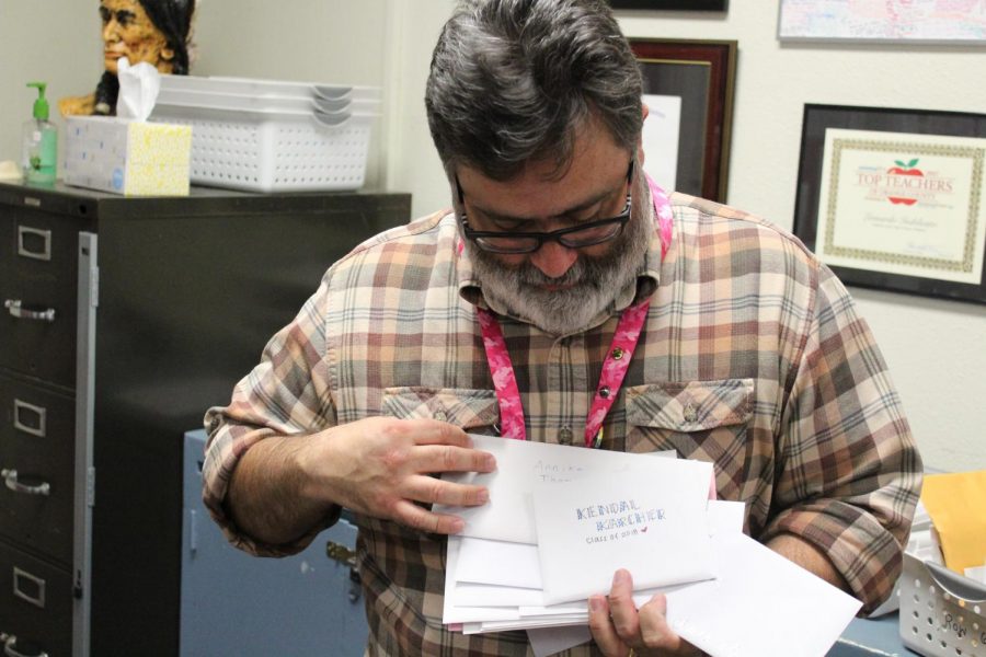English teacher Leonardo Indelicato flips through letters written by the class of 2018. Photo by Tyler Balsbaugh.