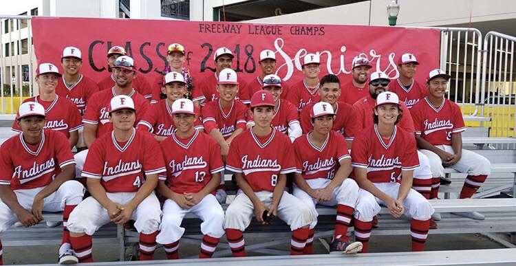 ​The baseball team sits in front of their League Champion banner. Photo courtesy of Matt Cho.