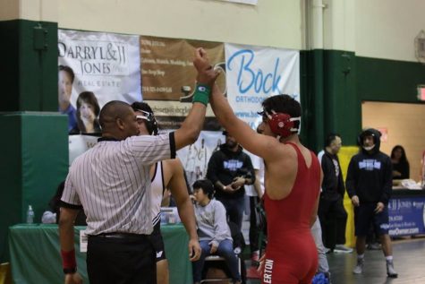Senior Isaul Castaneda getting his hand raised after pinning his opponent