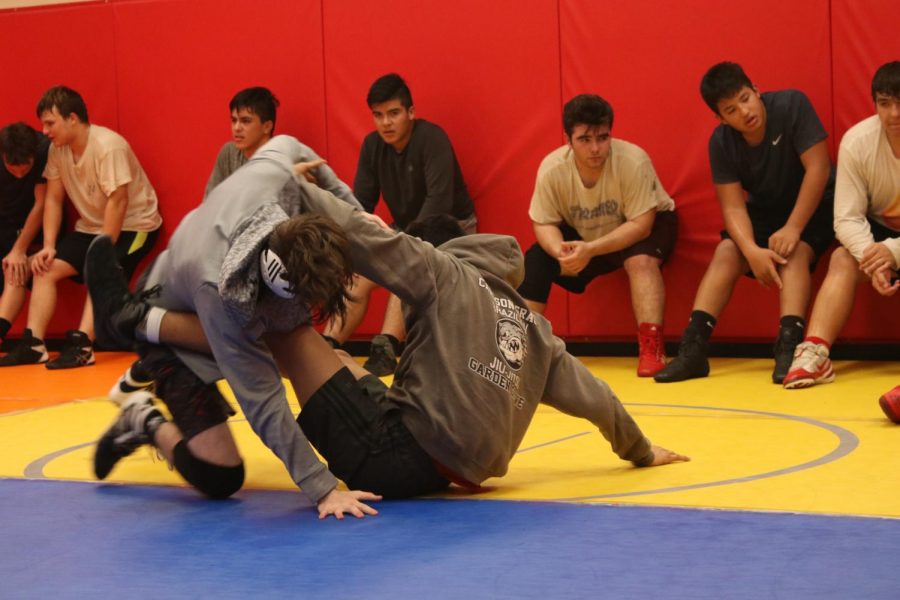 Seniors Jonothan Diaz and Connor Sessions (pictured) scramble while the rest of the wrestling team does wall sits in preparation for today’s individual tournament. The team will compete at the Downey 32 man tournament on Friday and Saturday. Senior Carlos Peña placed third at the Orange Lutheran Tournament. The team will travel to Troy on Dec. 19 at 6:30 p.m for its first dual meet. Photo by Betsy Barreto.
	
