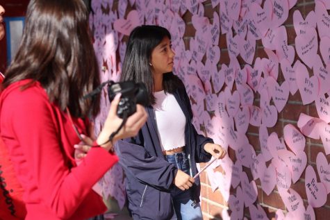 Freshman Summer Schutter searches the heart wall for her name. Photo by Jose Perez.