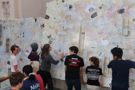 The tech crew plasters hundreds of children’s book pages onto flats to help set the scene for Matilda. Photo by Arashk Alivandi.