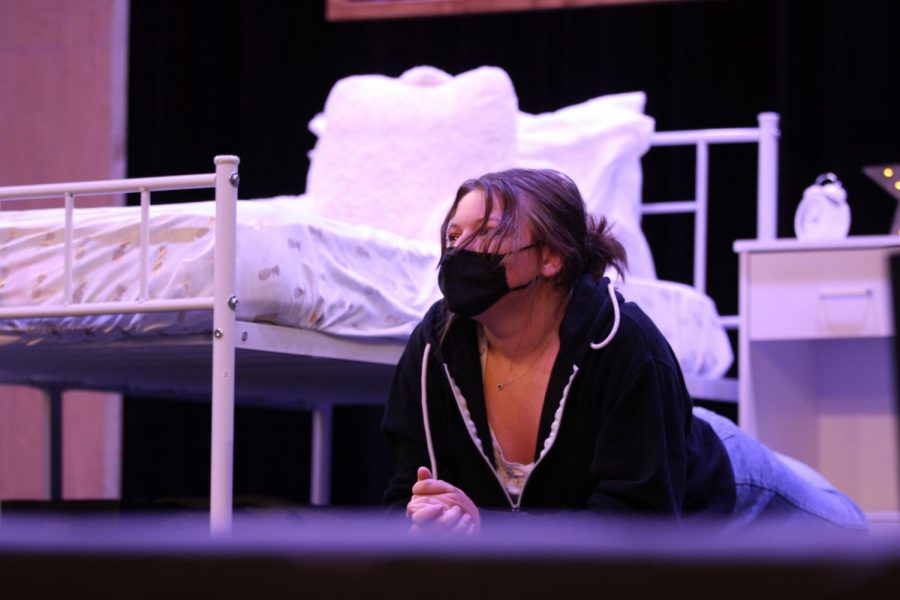 Junior Haley Cronin lies in front of the bedroom set crafted by the FUHS Technical Theatre class.
