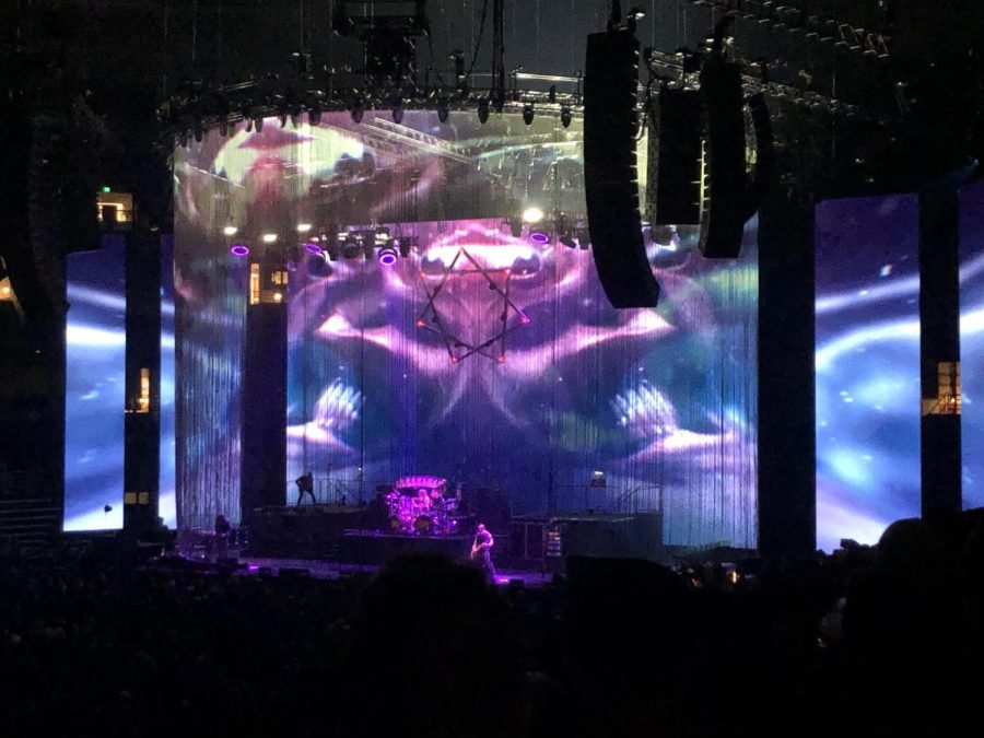 Tool performs as a wild array of visuals are displayed in front of and behind them.