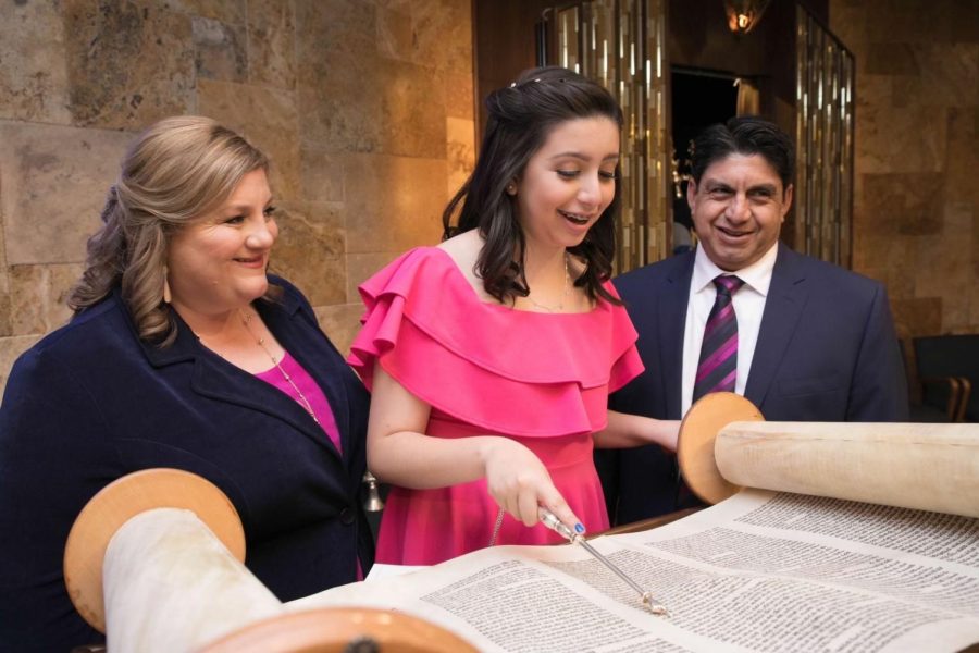 Melissa Galvan, Sophia Galvan, and Jason Galvan at the religious portion of Galvan’s Bat Mitzvah. Sophia is seen reading from the Torah.