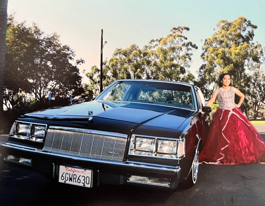 Senior Gina Hernandez poses next to her godfather’s Buick Regal lowrider during her quinceañera.