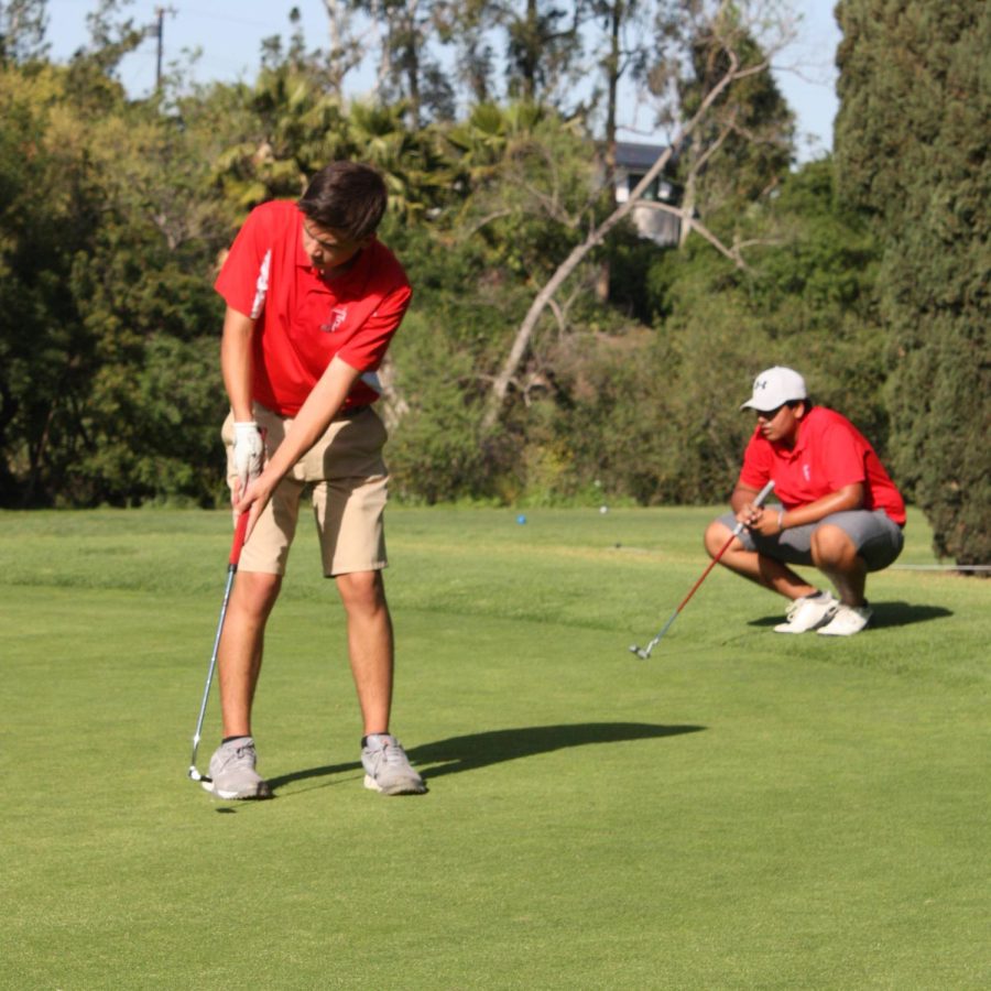 Junior Jack McMackin putts as sophomore Sangat Grewal looks on during a match against Troy on April 7. The Indians will face the Warriors again on April 26.