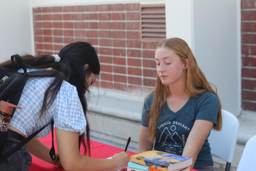 Junior Amelia Burns signs up new members for the Book Club during Club Rush.