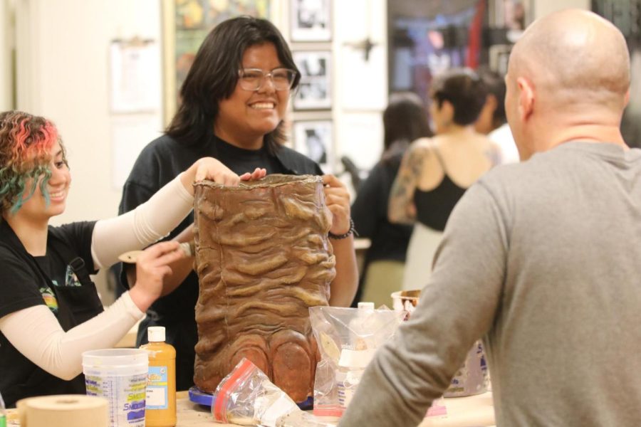 BEAST students seniors Larissa Bromley and Elizabeth Rivas converse with special effects and make-up artist Justin Raleigh about their process for painting the wooly mammoth foot.