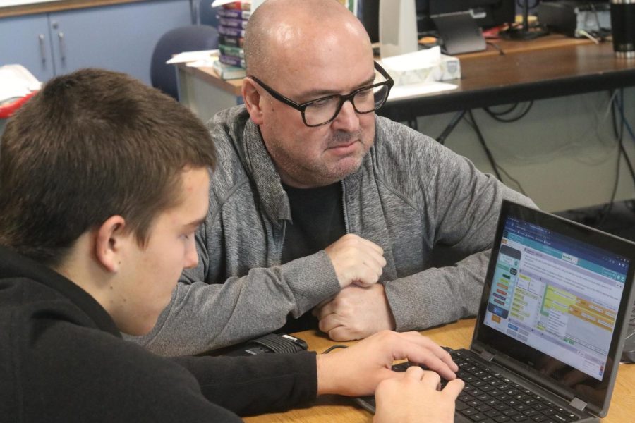 AP Computer Science teacher Jeff Oliva helps senior Christopher Osborn with coding an app to store weather data. Oliva says smoking is a tough addiction to overcome.