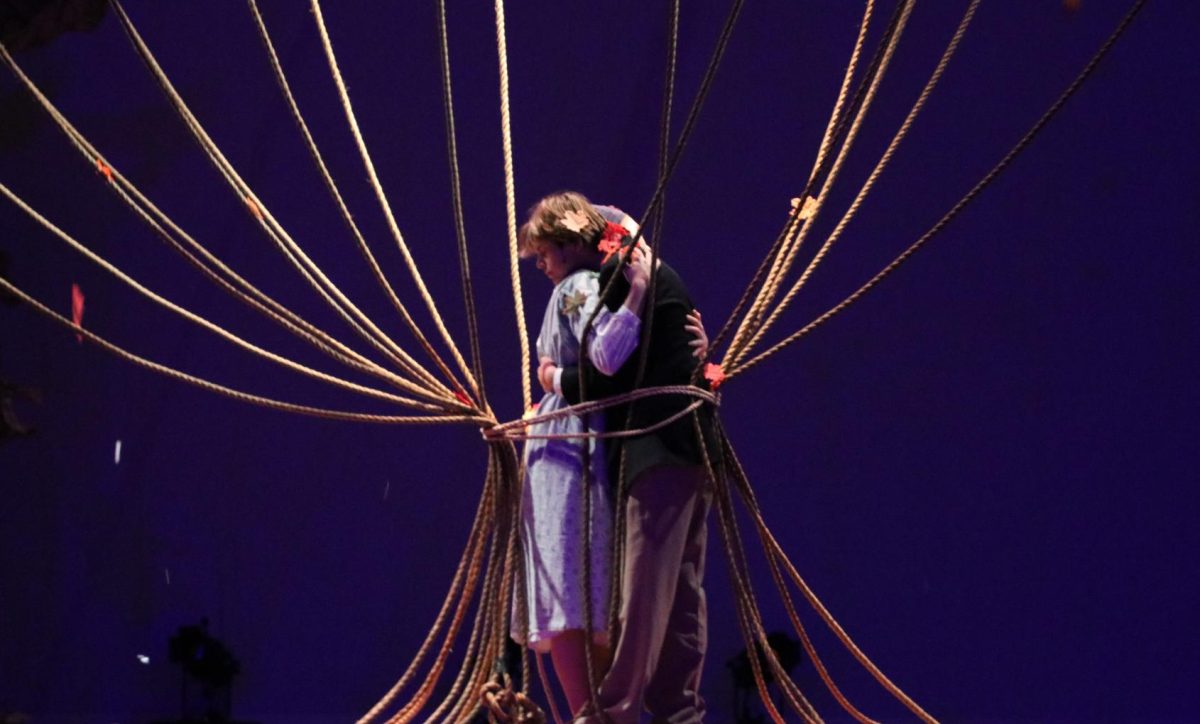 Conor and Mum embrace after a choreographed number involving the ensemble wrapping them with ropes symbolizing the tree branches.