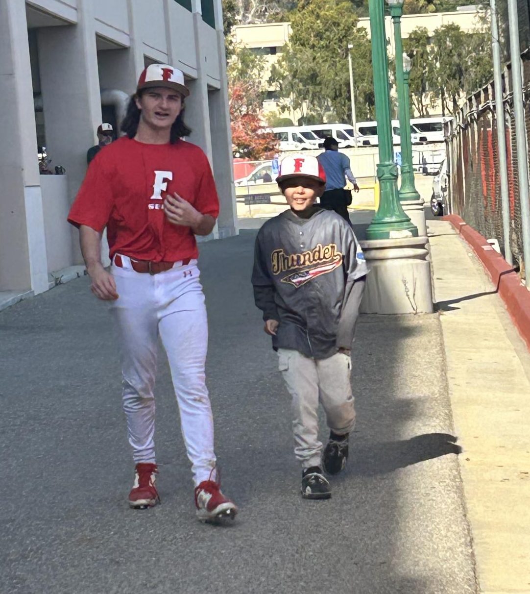 David (left) walks with Easton (right) at the baseball field. 
