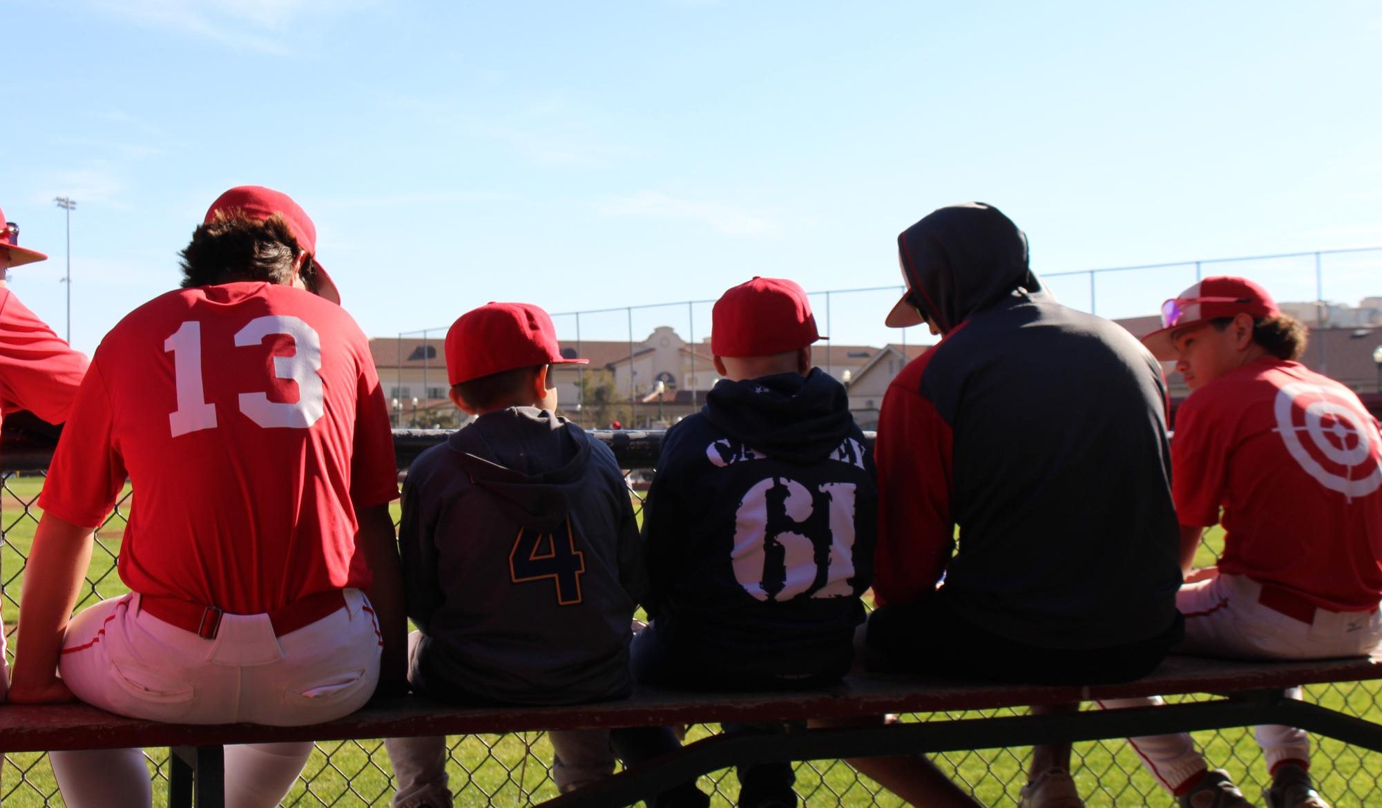 In the dugout, Easton Arceo (left) and Mikah Carney (right) talk with the FUHS baseball team. A lot of their conversations were about common interests such as food and sports. The team even included the boys in chirping the opponent team.