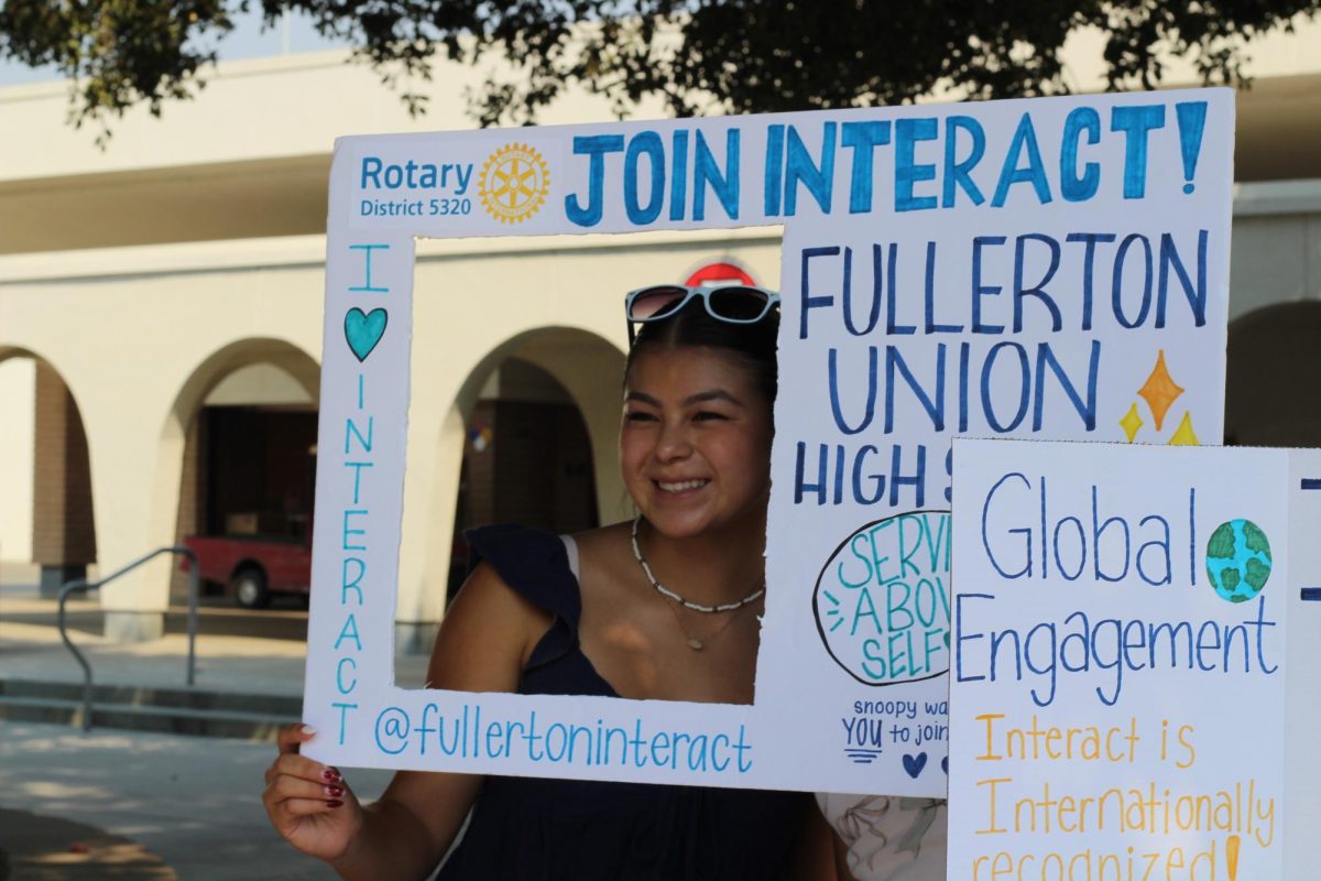 Senior Samantha Saldana poses with a sign promoting Interact Club. (Photo by Josie Lee )
