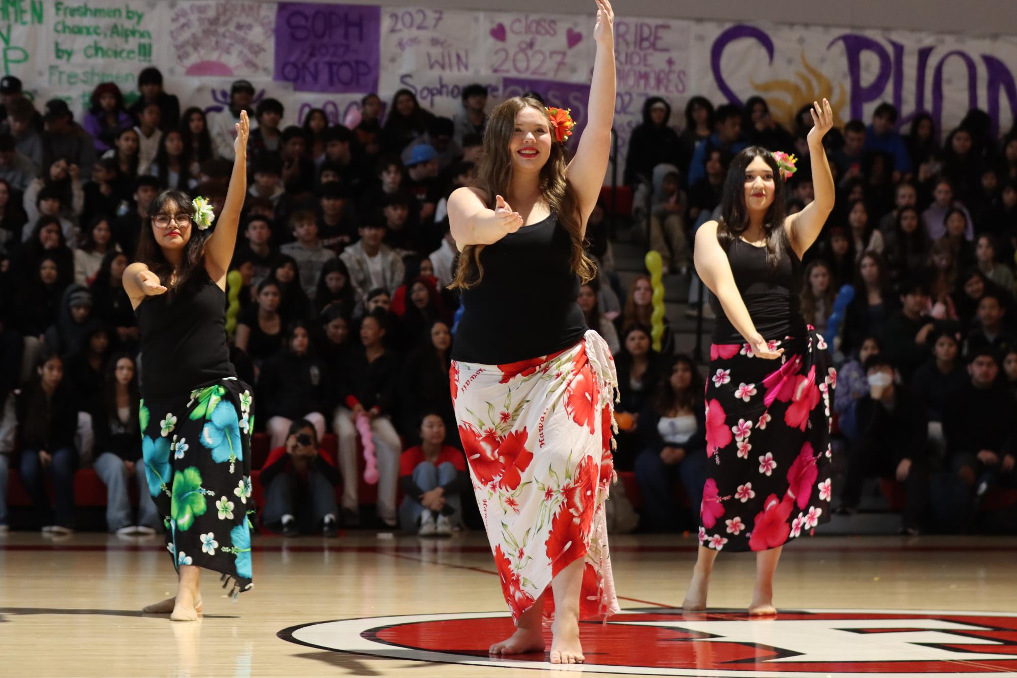 Sophomore Karina Montiel-Cruz (left), senior Aubrey Aguirre (center) and senior Ellen Munoz perform a traditional Hawaiian Hula dance during Fullerton's first IFF assembly.