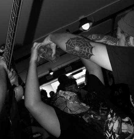 Skull Crack, a punk band, threw many cups of ranch  in the pit and crowd for their show at the Pizza Press in Santa Ana. At the end of their set, the bassist is seen to have ranch and beer poured into his mouth.