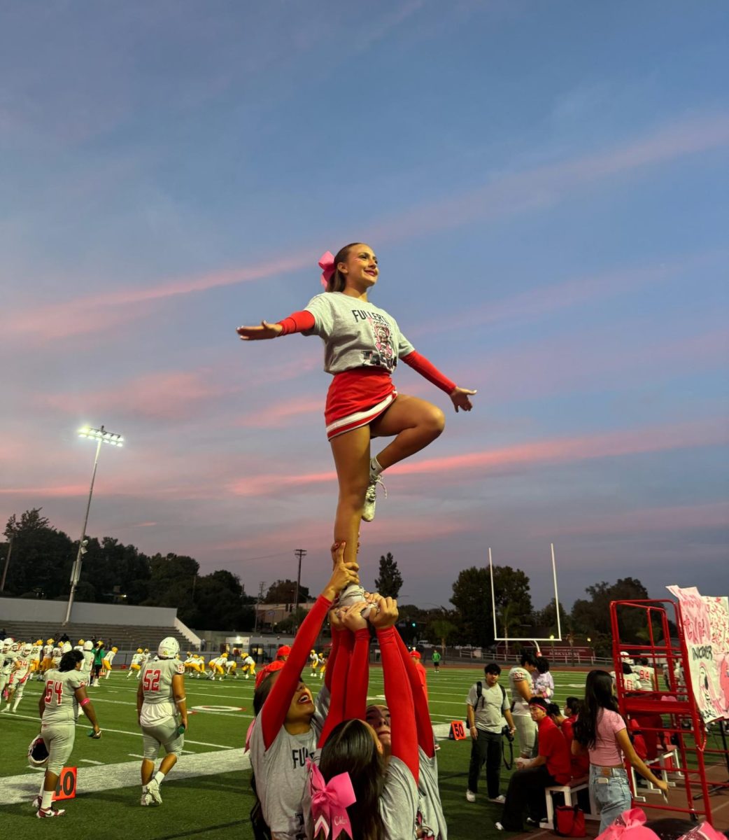 Junior Sunnie Dominguez performs a pyramid with her sophomore bases Isabella Kim, Kiley Rayle, and sophomore back spot Sienna Salcedo. Photo by Alyssa Rodriguez