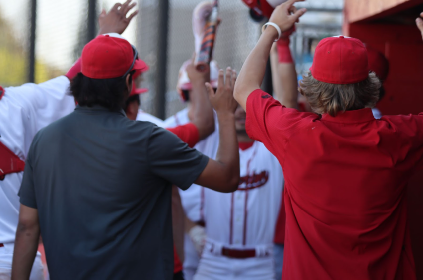 (From left to right) Senior Luke Galvan and junior Garrett Whiteman cheer on senior Zach Fany after scoring a run against Tustin on March 25. (Photo courtesy of Madison Sibal)
