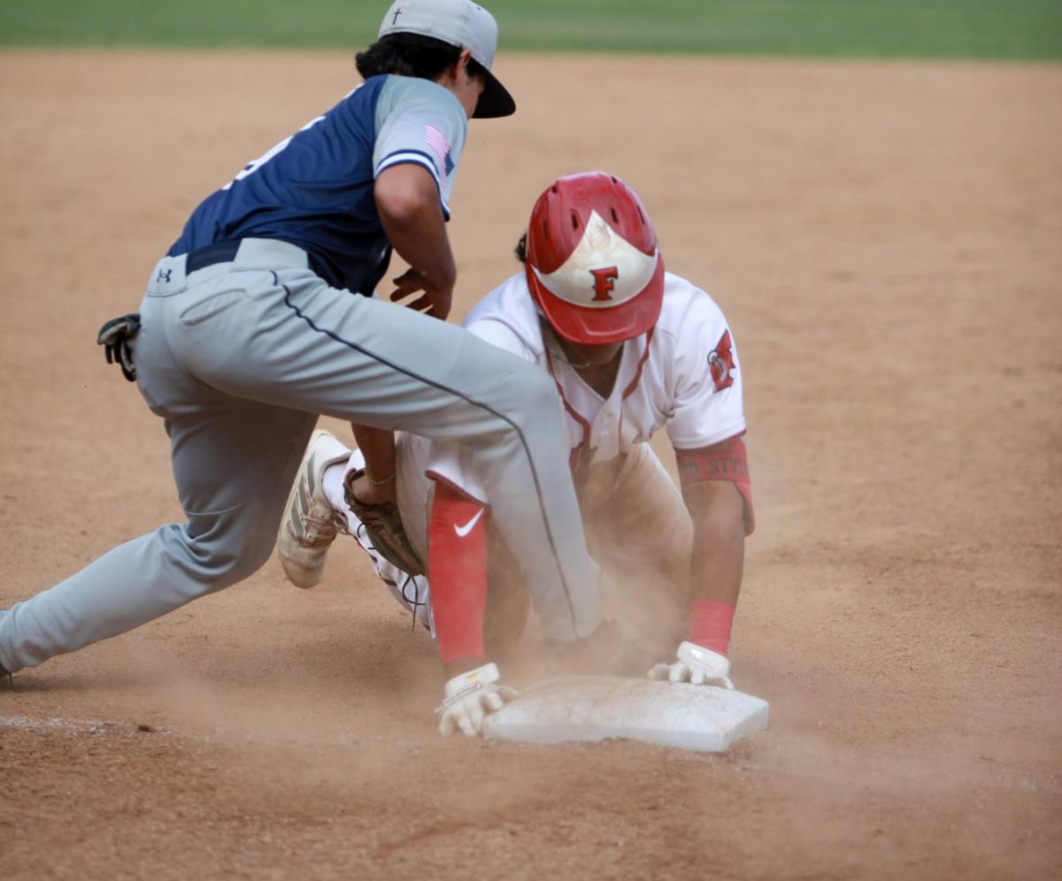 Senior Miguel Velazquez slides safely into third. Photo by Madison Sibal