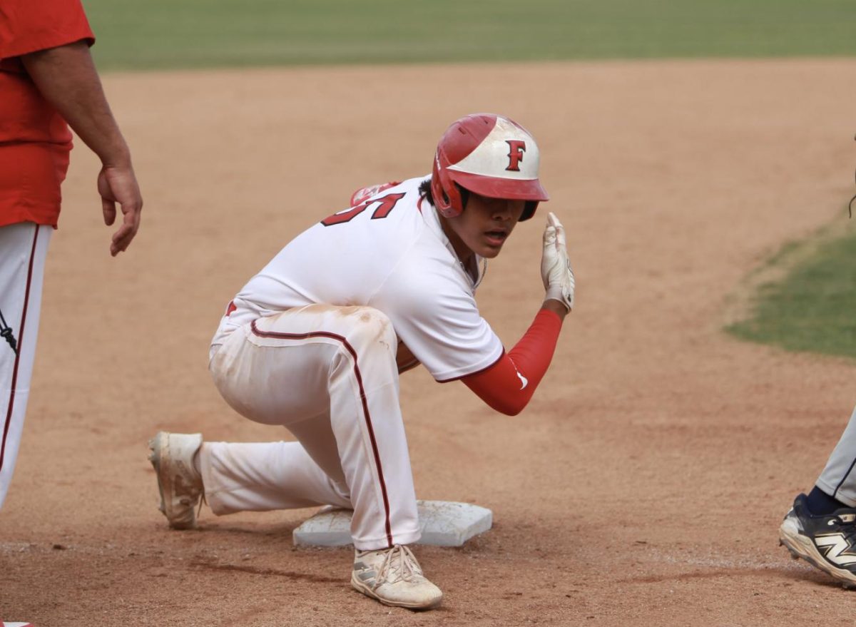 Senior Miguel Velazquez celebrates making it onto third. Photo by Madison Sibal