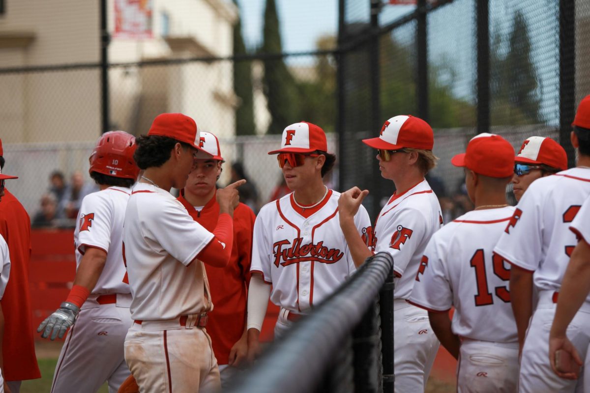 Senior Miguel Velazquez points to sophomore Lucas Delgadillo after a change in inning. Photo by Madison Sibal