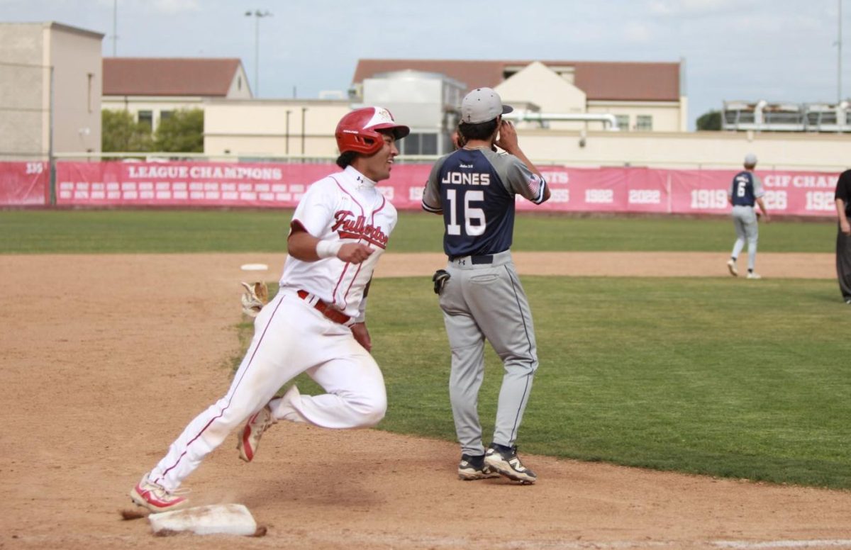 Senior Malachi Meni clears third and makes a beeline home to score a run against Calvary Chapel. Photo by Madison Sibal