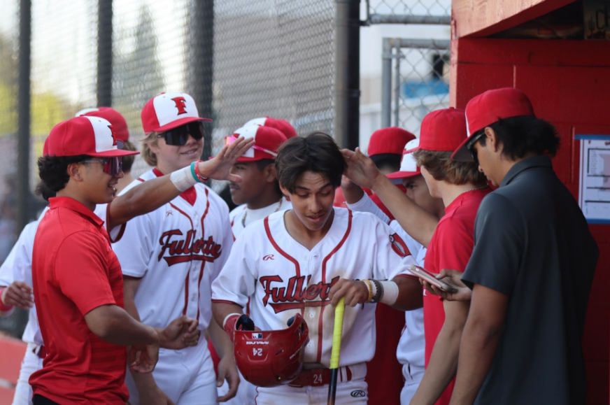(From left to right) Juniors Ronnie Martinez and Caden Wise, sophomore Logan Thien, juniors Evan Terrazas, Peter Vazquez, and Garrett Whiteman, and senior Luke Galvan celebrate senior Christian Robinson after scoring a run against Tustin. (Photo courtesy of Madison Sibal)