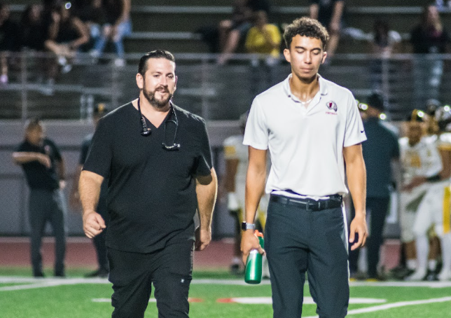 Doctor Matthew Varallo walks in tandem with the previous FUHS athletic trainer, Jacob Verket, after assisting an injured player on the field. Photo courtesy of Matthew Varallo