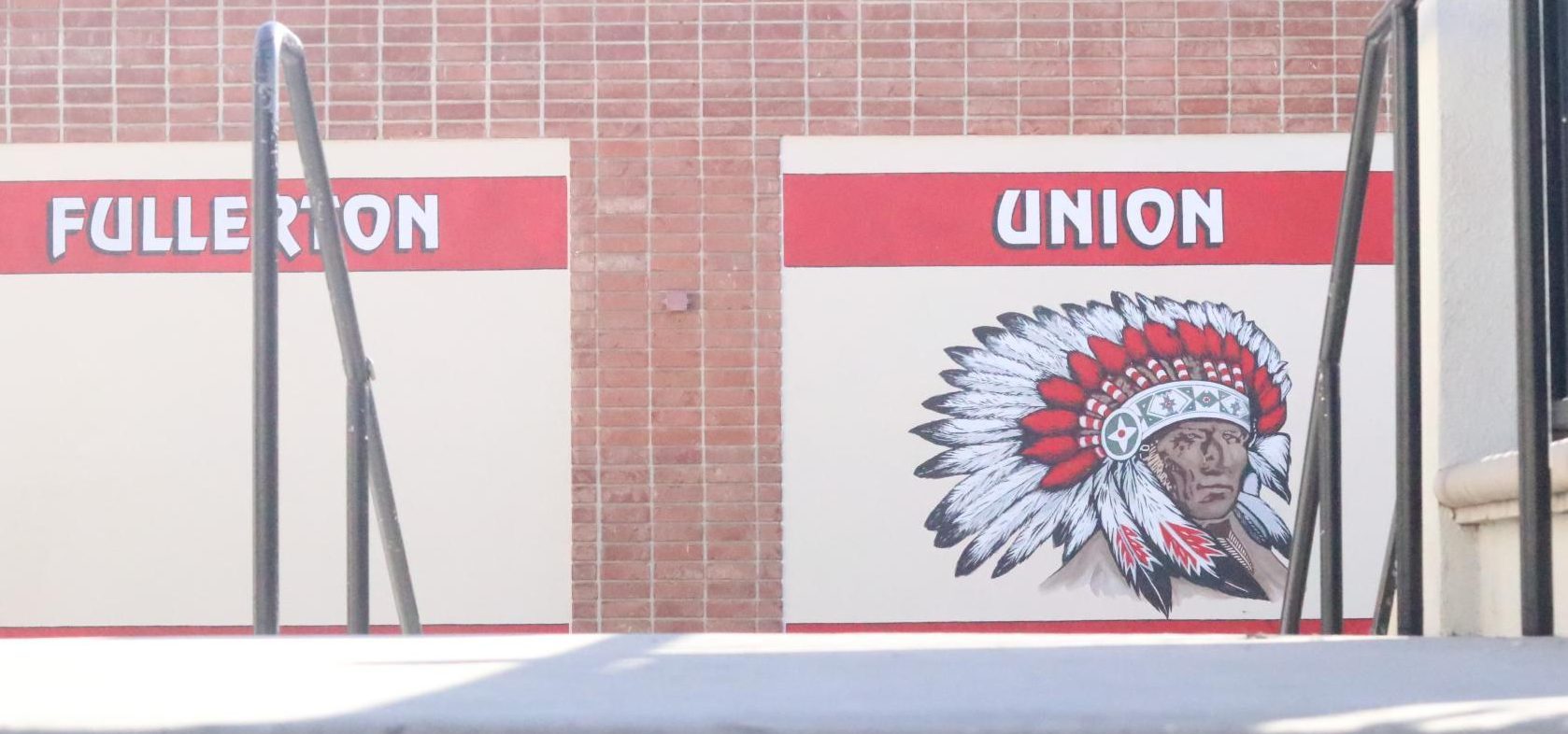 A mural depicting the Indian mascot rests on the side of the arts building. Students walking down the 200's Building stairs see this image each day.