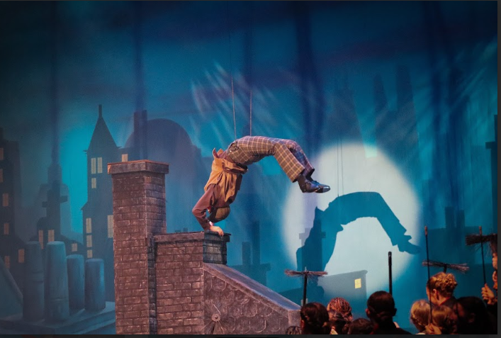 Sophomore Jacob Thompson does a backflip off of the chimney in the scene “Step in Time” during dress rehearsal. 