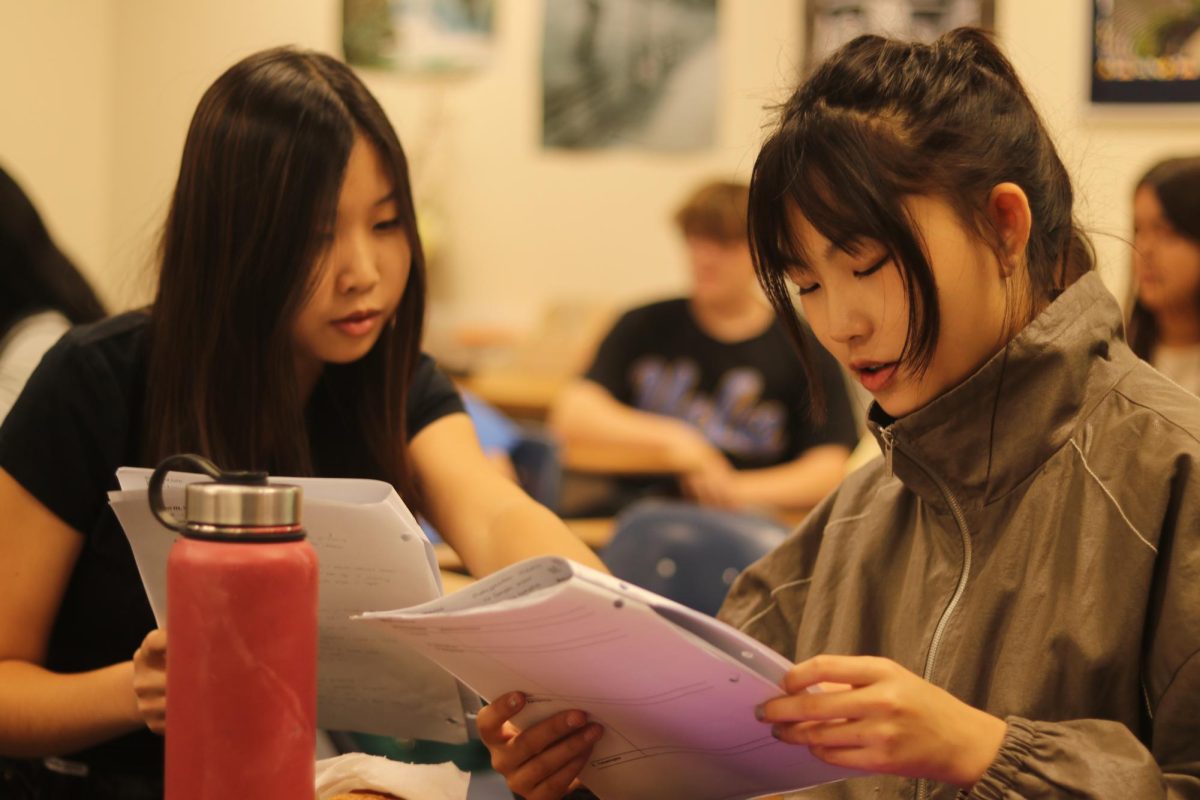Freshmen Jenna Hang (left) and Lauren Moon (right) discuss Romeo and Juliet in their Zero Period English class. The two students are scheduled to take Algebra 2 Honors for Zero Period next year; however, their new math class will meet only four days a week instead of five days. 